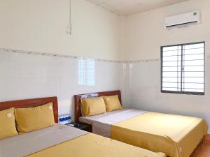 a room with two beds and a window at Le Condor 's House & Coffee in Con Dao