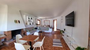 Villa Lucía - Benalmádena Costa في بينالمادينا: غرفة معيشة مع طاولة وكراسي ومدفأة
