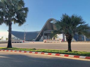 two palm trees in front of a building at Le Condor 's House & Coffee in Con Dao