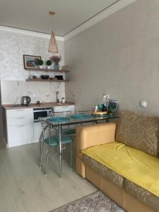 een woonkamer met een tafel en een bank bij Арбат apartment in Alma-Ata
