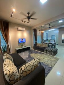 sala de estar con 2 sofás y TV en Homestay Aalaiya Bertam Kepala Batas - Fully Aircond en Kepala Batas