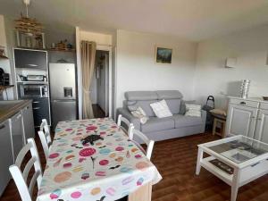 a kitchen and a living room with a table and a couch at Charmant 2 pièces avec vue sur mer à Porticcio en Corse du Sud in Porticcio