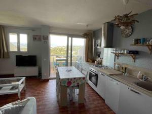 a kitchen with a table in the middle of a room at Charmant 2 pièces avec vue sur mer à Porticcio en Corse du Sud in Porticcio +4 photos
