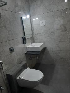 a bathroom with a white toilet and a sink at Raapan Beach Resort in Malvan