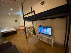 a living room with a tv and a bunk bed at Burgos Hub Hostel in Manila