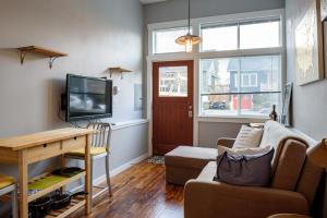 a living room with a couch and a tv at Tiny House by KABINO Mini Modern TINY HOME Heart of Green Lake Pet Friendly WiFi Loft up Ladder plus Sleeper Sofa in Seattle