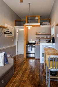 西雅圖的住宿－Tiny House by KABINO Mini Modern TINY HOME Heart of Green Lake Pet Friendly WiFi Loft up Ladder plus Sleeper Sofa，厨房以及带沙发和炉灶的客厅。