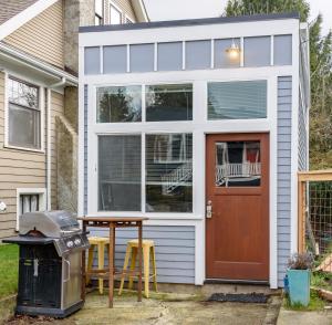 西雅圖的住宿－Tiny House by KABINO Mini Modern TINY HOME Heart of Green Lake Pet Friendly WiFi Loft up Ladder plus Sleeper Sofa，一间小房子,有红色的门和桌椅