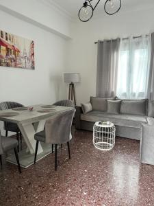 Technopolis Luxury Apartments في أثينا: غرفة معيشة مع أريكة وطاولة وكراسي