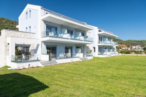 a white apartment building with a large yard at Notia Luxury Living in Porto Koufo