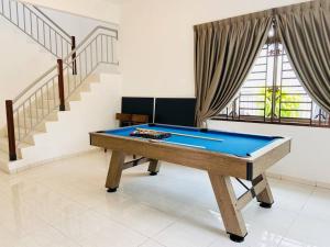 a pool table in a room with a staircase at Nestle Homestay@Batu Pahat in Batu Pahat