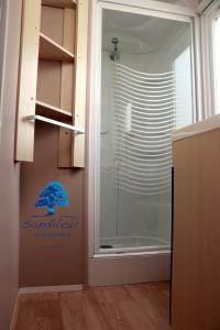 ein Badezimmer mit einer Glastür mit einem Schild darauf in der Unterkunft Mobilhome Le repaire du soleil in Sigean