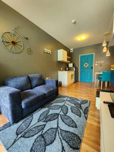 a living room with a blue couch and a kitchen at The Trust Condo by the Sea in Hua Hin