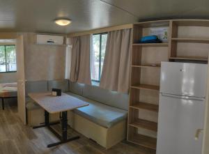 una pequeña cocina con mesa y nevera en Mobile homes Pine Sea Banjole, en Banjole