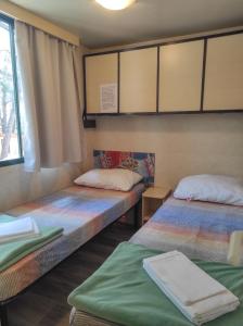een kamer met 2 bedden en een raam bij Mobile homes Pine Sea Banjole in Banjole