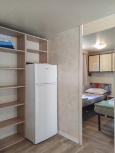 een keuken met een koelkast en een kamer met een bed bij Mobile homes Pine Sea Banjole in Banjole