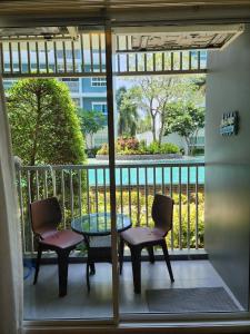 a patio with two chairs and a table and a table and chairs at The Trust Condo by the Sea in Hua Hin