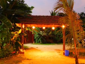 a gazebo in the middle of a yard at night at Gram Bangla Retreat in Kolkata