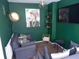 a living room with green walls and a couch at JB Stays /Free Parking/Family/Contractors in South Norwood