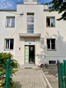 un edificio blanco con una puerta verde en Endla Hostel ja Apartamendid en Haapsalu
