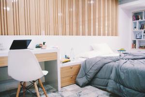 um quarto com uma cama e uma secretária com um computador portátil em Double Studio, Private Bath, Shared Kitchen with Local Family by Pillows & Purrs em Bangkok