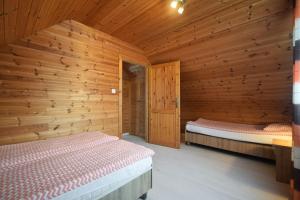 a bedroom with two beds in a wooden cabin at Stecyk - Domki nad morzem, Trzęsacz in Trzęsacz