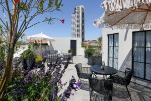 a patio with a table and chairs and flowers at Allegro Neve Tzedek Boutique Suites - By HOMY in Tel Aviv