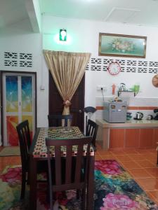 a dining room with a table and a kitchen at Room 345 in Kota Bharu