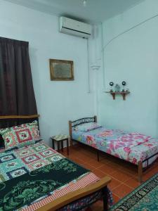 um quarto com duas camas e uma mesa e uma janela em Room 345 em Kota Bharu