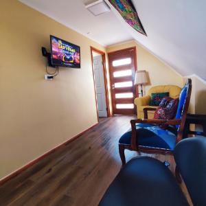 ein Wohnzimmer mit einem Sofa und einem TV an der Wand in der Unterkunft Acogedor departamento interior con acceso independiente y estacionamiento in La Serena