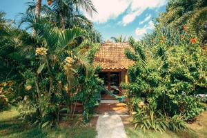 a house with a garden with palm trees at Coconut Garden Resort in Gili Trawangan