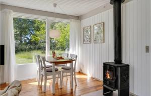 ein Esszimmer mit einem Tisch und einem Holzofen in der Unterkunft Awesome Home In Grevinge With Wifi in Grevinge