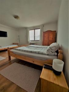 a bedroom with a large bed with a wooden frame at Szenkeparti Vendégház in Penyige