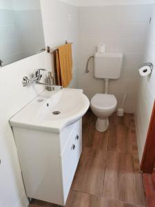 a bathroom with a white sink and a toilet at Szenkeparti Vendégház in Penyige +15 photos