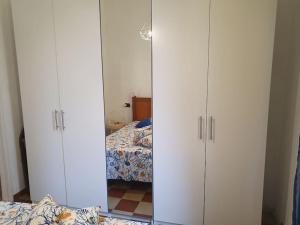 Appartamento a 100 metri dal mare في فرامورا: زوج من الدواليب البيضاء في غرفة النوم مع سرير