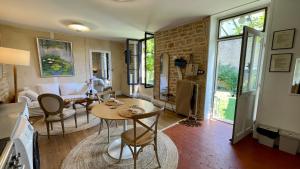 MonCoeur, maison et jardin à 700 m des Hospices de Beaune في بون: مطبخ وغرفة معيشة مع طاولة وكراسي