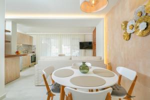 a kitchen and dining room with a white table and chairs at Dagos Luxury Apartments in Limenas +18 photos