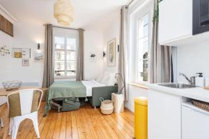 a kitchen with a room with a bed in it at Studio front de mer en centre-ville de Cabourg in Cabourg