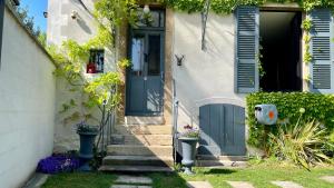 una casa con una puerta azul y escaleras en MonCoeur, maison et jardin à 700 m des Hospices de Beaune en Beaune