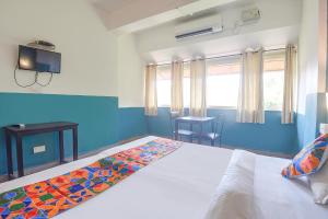 Schlafzimmer mit einem Bett, einem Tisch und einem TV in der Unterkunft FabExpress Paradise Inn Panaji in Velha Goa