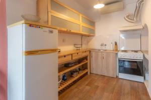 uma cozinha com um frigorífico branco e pisos em madeira em Annas Horizon em Samothráki