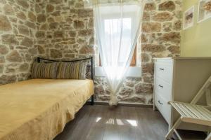 um quarto com uma cama e uma parede de pedra em Annas Horizon em Samothráki