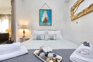 1 dormitorio con cama blanca y bandeja de toallas en Gallery Home, en Skopelos Town