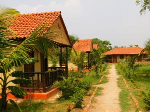 una casa con un camino de tierra al lado de un patio en Gram Bangla Retreat en Calcuta