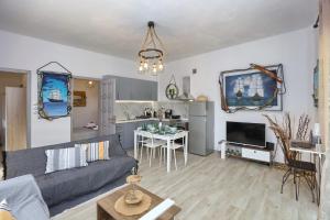 salon z szarą kanapą i kuchnią w obiekcie Gallery Home w mieście Skopelos