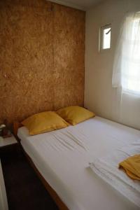 een bed met twee kussens in een slaapkamer bij Basic Natuurhuisje Ommen/Beerze in Beerze