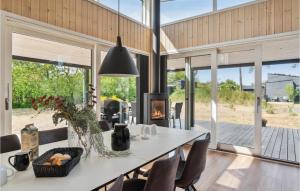 a dining room with a table and chairs and a fireplace at Cozy Home In Nex With Kitchen in Snogebæk