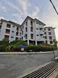 a large white apartment building on the side of the street at Titi Panjang Apartment Lumut Sitiawan Manjung in Lumut