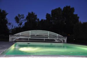a swimming pool at night with a building at la ferme de tonton Jules 1 in Entraigues-sur-la-Sorgue