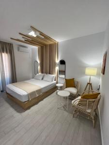 um quarto com uma cama grande e uma cadeira em Akroyiali Resort em Vasiliki